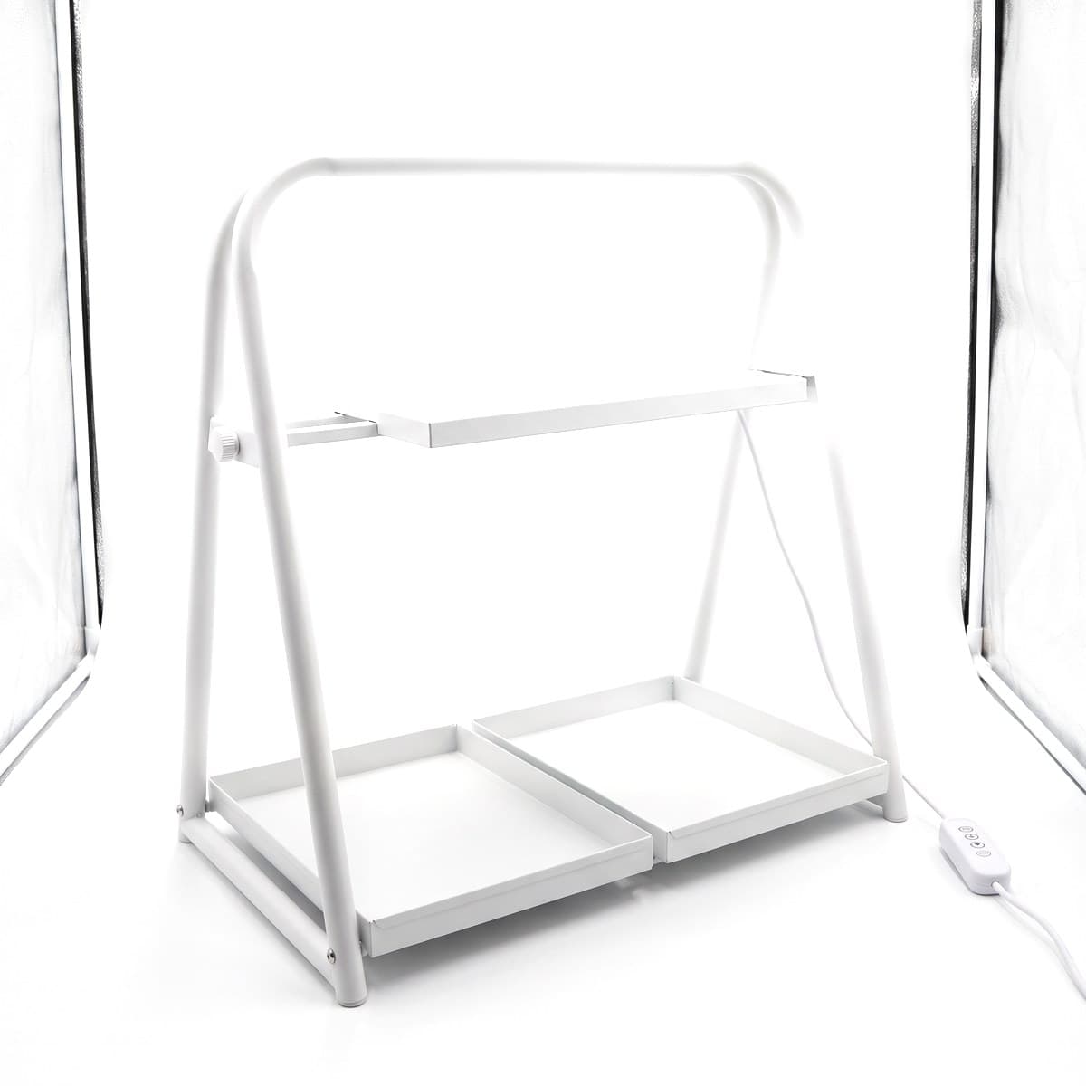A white steel tabletop grow light garden with an LED panel on a sliding arch over two trays