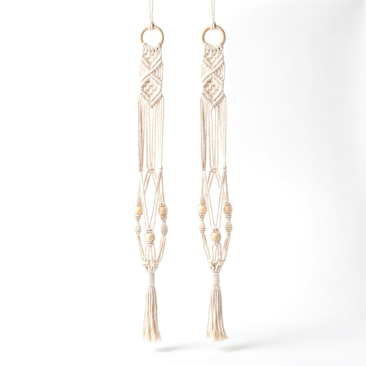 Two hand-knotted cream cotton macrame plant hangers, each with a wooden ring and beads